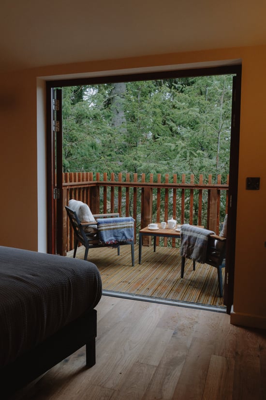 Unfurl Treehouse cabin decking overlooking the forest at Forest Holidays