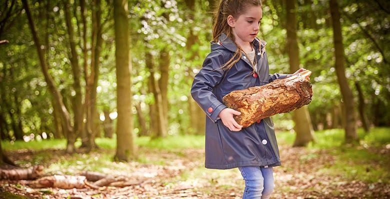 Girl carrying logs in the forest